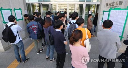 지난 5월 24일 오후 서울 서대문구 연세대학교 중앙도서관 앞에서 학생들이 성 칼럼니스트 겸 작가 은하선 씨의 강연에 대한 찬반 의견이 적힌 대자보를 살펴보고 있다. <연합뉴스>